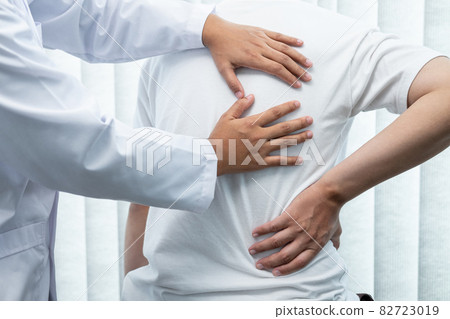 Physiotherapist working examining treating injured back of athlete male patient, Doctor doing the rehabilitation therapy pain Physiotherapist working examining treating injured back of athlete male patient, Doctor doing the rehabilitation therapy pain 82723019