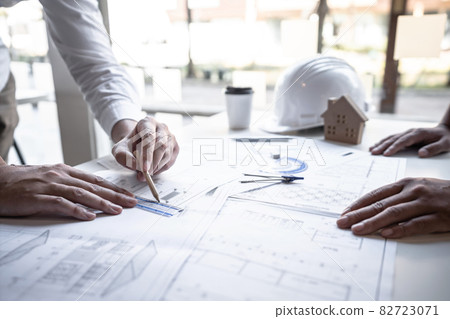Architects or engineering team consulting and analyzing working on objects tools and construction drawings inspection planning new architectural project on blueprint and model house in modern office Architects or engineering team consulting and analyzing working on objects tools and construction drawings inspection planning new architectural project on blueprint and model house in modern office 82723071