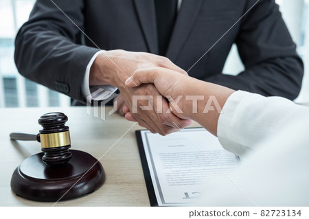 Male lawyer shaking hands with client after good deal negotiation cooperation meeting in courtroom 82723134