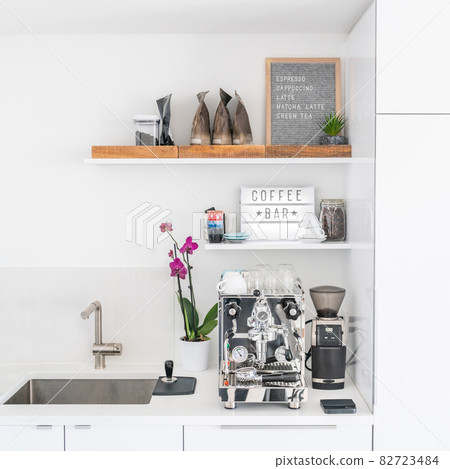 Luxury modern white kitchen with professional barista espresso machine on quartz countertop. Square crop of interior design background 82723484