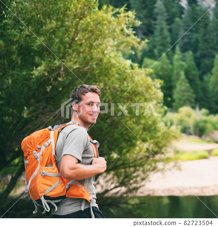 Summer camp young man on travel hike happy hiker walking with camping backpack in forest trek trail Summer camp young man on travel hike happy hiker walking with camping backpack in forest trek trail 82723504