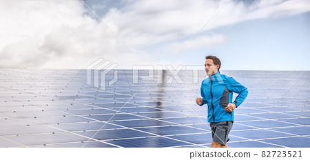 Solar panels farm runner active man athlete jogging by outdoor background header panoramic 82723521