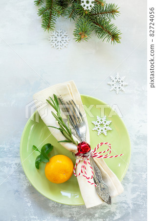 Decor Christmas table on stone background. Green plate, cutlery and decorations. Top view. 82724056