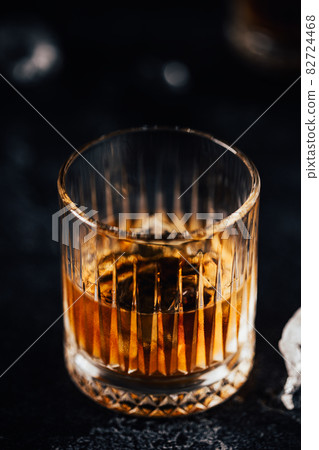 Whiskey with ice on a dark table 82724468