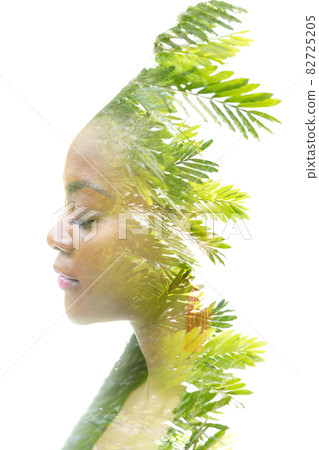 A portrait of an African American woman combined with an image of green foliage in a double exposure technique. A portrait of an African American woman combined with an image of green foliage in a double exposure technique. 82725205