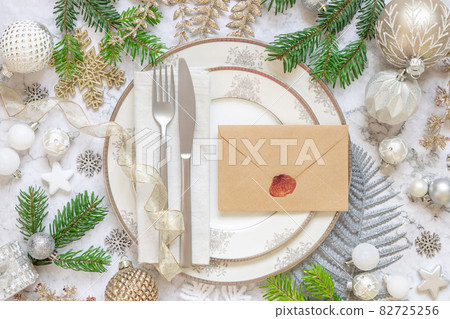 Festive table setting with fir tree branches and Christmas decorations Festive table setting with fir tree branches and Christmas decorations 82725256