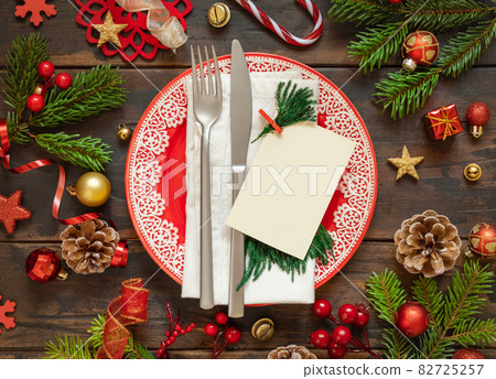 Festive table setting with fir branches and Christmas decorations Festive table setting with fir branches and Christmas decorations 82725257