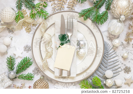 Festive table setting with fir branches, card and Christmas decorations Festive table setting with fir branches, card and Christmas decorations 82725258