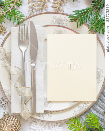 Festive table setting with fir tree branches and Christmas decorations Festive table setting with fir tree branches and Christmas decorations 82725259