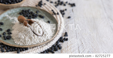 Plate with black beans flour with a wooden scoop 82725277