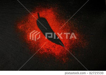 Red chili pepper silhoutte isolated on black slate board. Top view. 82725530