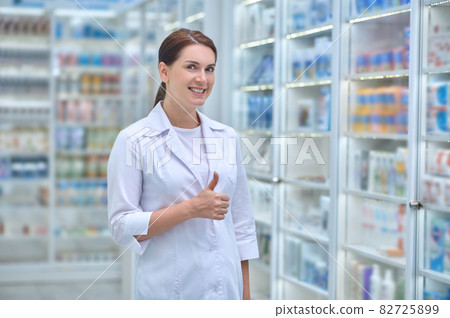 Happy woman in white coat in pharmacy Happy woman in white coat in pharmacy 82725899