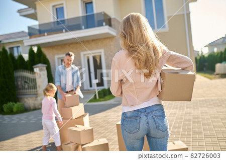 Woman with box heading to husband with daughter Woman with box heading to husband with daughter 82726003