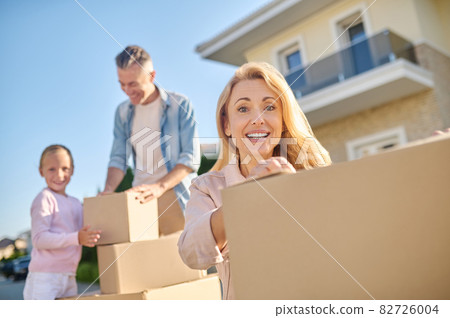Pretty woman crouched near boxes of things 82726004