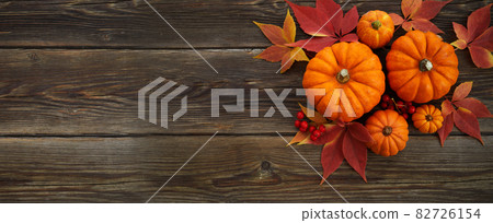 Framework with pumpkins and fall leaves on wooden background. Top view. Framework with pumpkins and fall leaves on wooden background. Top view. 82726154