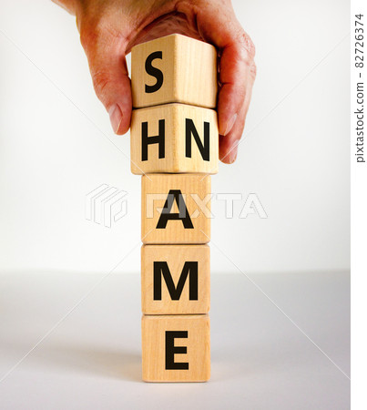 Name or shame symbol. Businessman turns wooden cubes and changes the word 'shame' to 'name' or vice versa. Beautiful white background, copy space. Business, name or shame concept. Name or shame symbol. Businessman turns wooden cubes and changes the word 'shame' to 'name' or vice versa. Beautiful white background, copy space. Business, name or shame concept. 82726374
