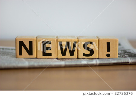 Cubes placed on a newspaper form the word 'news'. Beautiful wooden table. White background. Business concept. Copy space. Cubes placed on a newspaper form the word 'news'. Beautiful wooden table. White background. Business concept. Copy space. 82726376