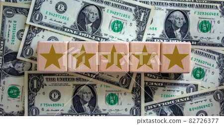 Wood cubes with gold star sign on dollar bills, copy space. Quality and luxury conceptual image. Wood cubes with gold star sign on dollar bills, copy space. Quality and luxury conceptual image. 82726377