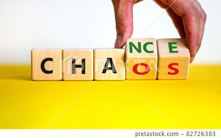 Chance or chaos symbol. Businessman turns wooden cubes and changes the word 'chaos' to 'chance'. Beautiful yellow table, white background, copy space. Business, chaos or chance concept. Chance or chaos symbol. Businessman turns wooden cubes and changes the word 'chaos' to 'chance'. Beautiful yellow table, white background, copy space. Business, chaos or chance concept. 82726383