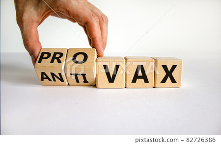 Pro-vax or anti-vax symbol. Doctor turns a cube, changes words 'anti-vax' to 'pro-vax'. Beautiful white background. Copy space. Business, medical covid-19 pro-vax or anti-vax concept. Pro-vax or anti-vax symbol. Doctor turns a cube, changes words 'anti-vax' to 'pro-vax'. Beautiful white background. Copy space. Business, medical covid-19 pro-vax or anti-vax concept. 82726386