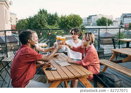Group of happy friends toasting by table in outdoor cafe 82727071
