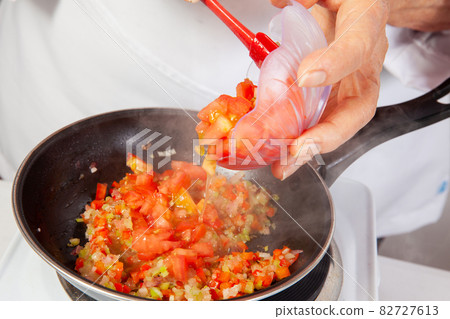 Preparation of the traditional Colombian hogao or criollo sauce (salsa criolla) made of onion, tomato, peppers and cilantro 82727613