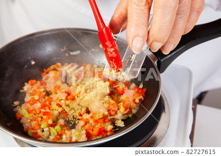 Preparation of the traditional Colombian hogao or criollo sauce (salsa criolla) made of onion, tomato, peppers and cilantro 82727615