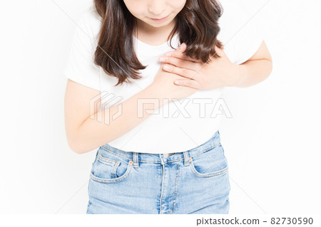 Young woman wearing a T-shirt with her hands on her chest Young woman wearing a T-shirt with her hands on her chest 82730590