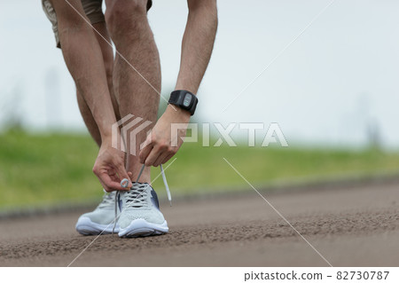 Utilization of smart watches ・ Men's hands tying shoelaces Utilization of smart watches ・ Men's hands tying shoelaces 82730787
