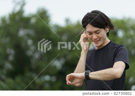 鍛煉和使用智能手錶的年輕人 鍛煉和使用智能手錶的年輕人 82730802
