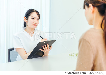 A woman in a lab coat worried about her patient A woman in a lab coat worried about her patient 82733472