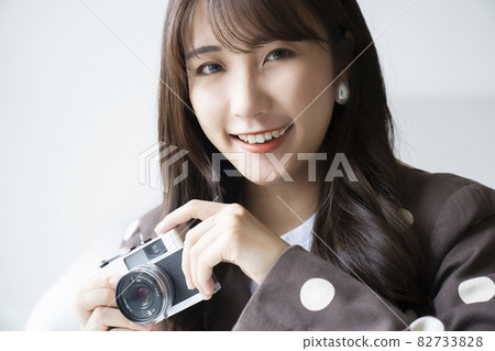 Camera and fashionable woman portrait 82733828