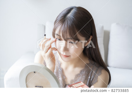 Woman doing make-up Woman doing make-up 82733885