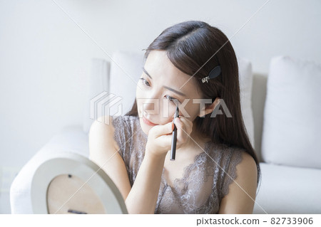 Woman doing make-up Woman doing make-up 82733906