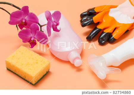 Bottles of dishwashing liquid and sponge on a beige background. 82734860