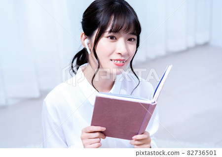 一個獨自生活的年輕女子,假期在客廳裡邊聽音樂邊讀書 一個獨自生活的年輕女子,假期在客廳裡邊聽音樂邊讀書 82736501