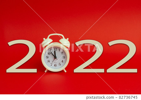 Celebrating new year. New 2022 year made with alarm clock on red background. 82736745