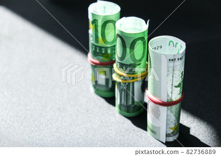 Close up of Euro money roll. Euro banknote set cash money - EU currency. Rolled with rubber euro notes. Banknotes stacked on each other in different positions 82736889