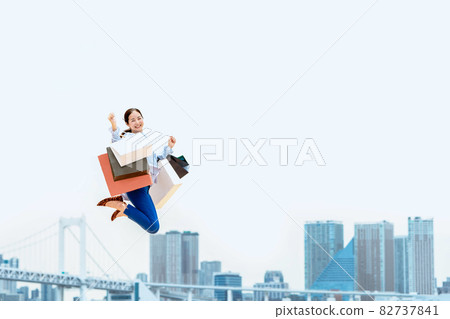 A woman who jumps with a lot of shopping bags (sale / explosive buying) 82737841