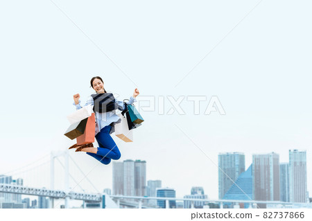 A woman who jumps with a lot of shopping bags (sale / explosive buying) 82737866