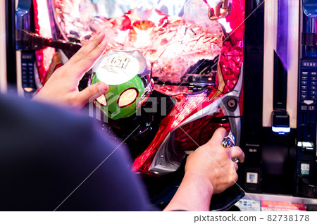 Hands playing on a pachinko machine Hands playing on a pachinko machine 82738178