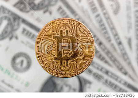 The golden bitcoin, us dollars banknotes on a background 82738426
