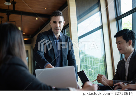 Multiracial business people gather to discuss the company's market plan for the coming year. Teamwork Togetherness Unity Concept. Multiracial business people gather to discuss the company's market plan for the coming year. Teamwork Togetherness Unity Concept. 82738614