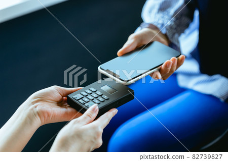 Women making smartphone payments (hands, body parts, up) 82739827