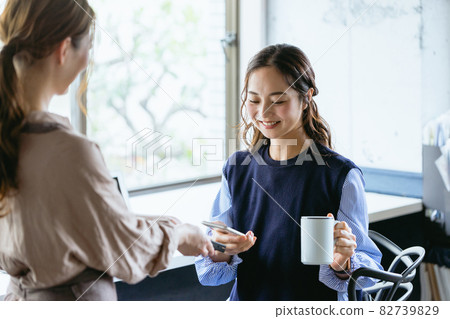 一位女士在咖啡館（共享辦公空間）用智能手機付款 82739829