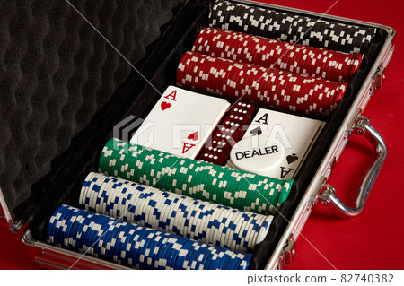 Poker set in metal suitcase. Risky entertainment of gambling. Top view on red background 82740382
