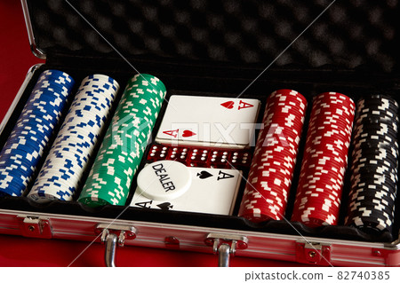 Poker set in metal suitcase. Risky entertainment of gambling. Top view on red background 82740385