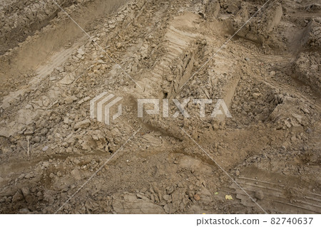 Wheel trail on sandy ground from large transport, tractor on construction site, sandy road Wheel trail on sandy ground from large transport, tractor on construction site, sandy road 82740637