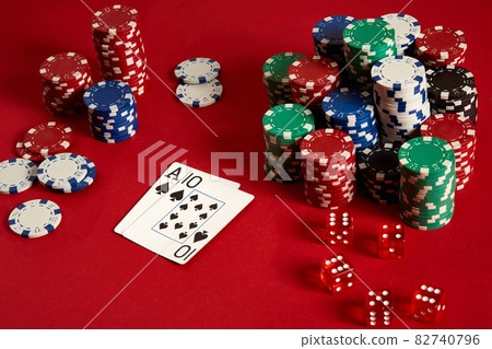 Two cards and chips on a red background. Big bet of game money. Cards - Ace and Ten. Your distribution at the table 82740796