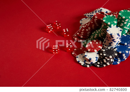 Poker chips on red background. Group of different poker chips. Casino background. Poker chips on red background. Group of different poker chips. Casino background. 82740800